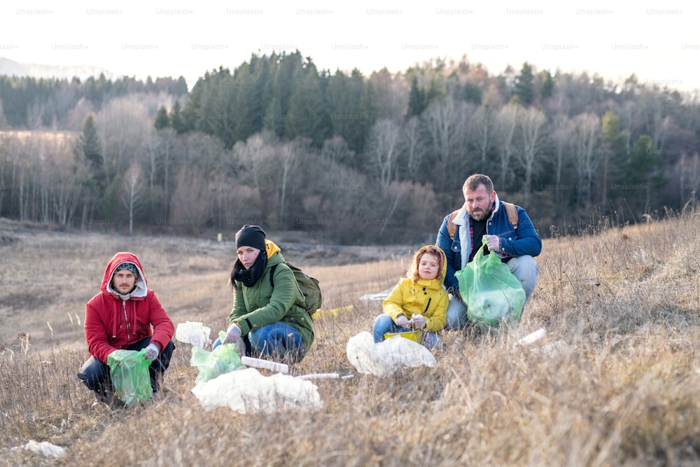Gruppo di attivisti che raccolgono rifiuti in natura, inquinamento ambientale e concetto di plogging