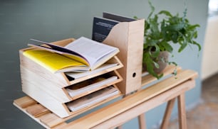Paper and document wooden tray holders and organisers on desk with plant, natural decor concept.