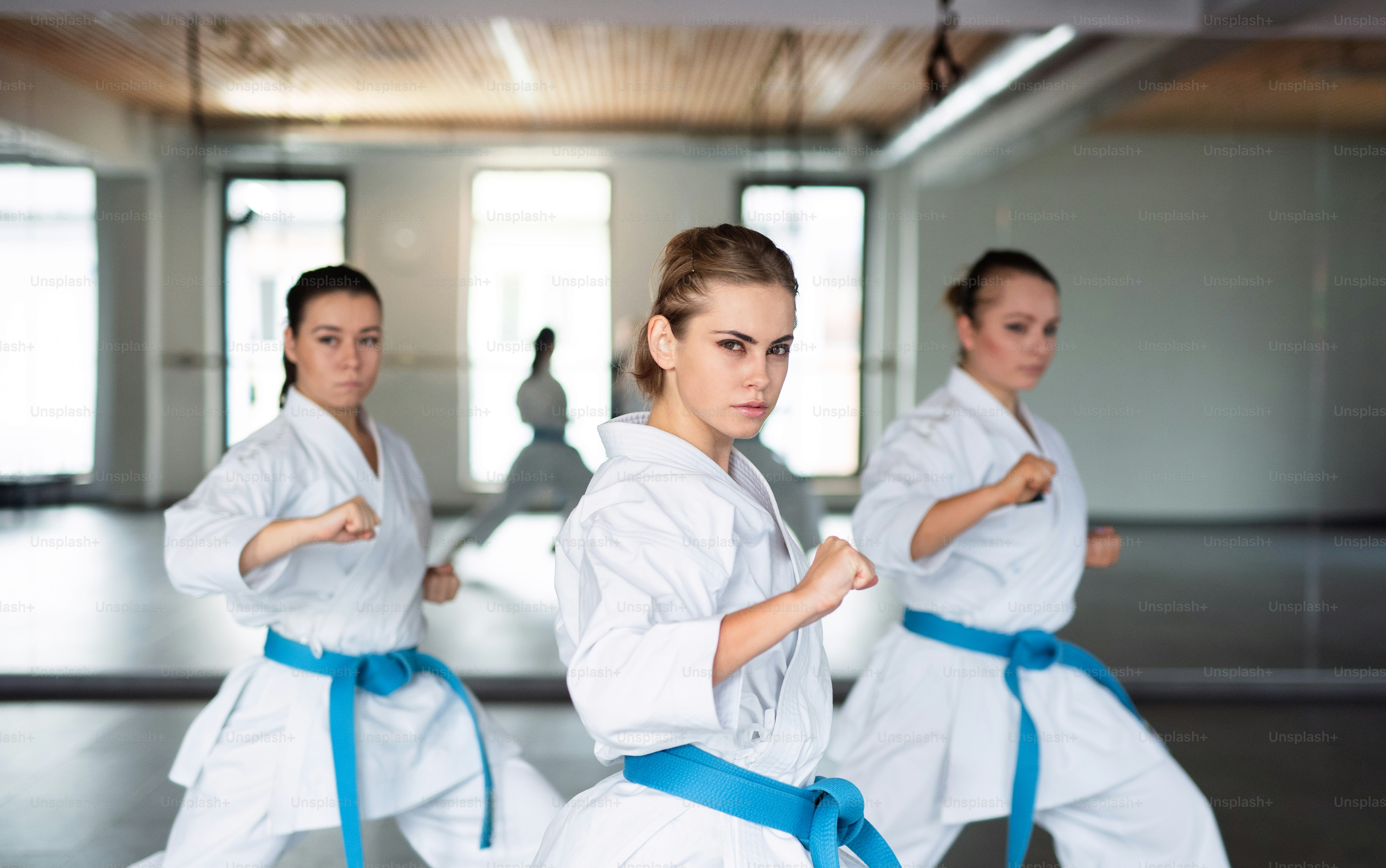 Un gruppo di giovani donne che praticano karate al chiuso in palestra.