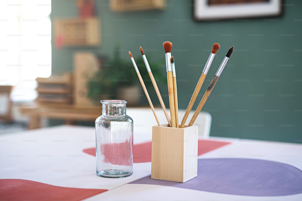 Contenitore in legno con pennelli sulla scrivania, un concetto di arredamento naturale.