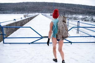 겨울에 야외에서 수영복을 입은 활동적인 노인 여성의 뒷모습, 감기 치료 개념.