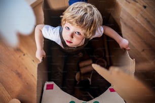 Una vista dall'alto del bambino biondo che gioca all'interno di casa. Copia spazio.