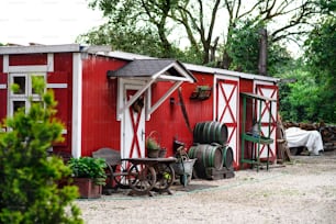 Edifício rural da fazenda vermelha e branca no dia de verão.