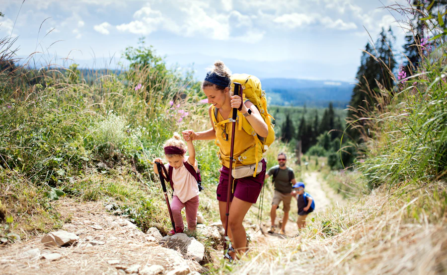 A happy family with small children hiking outdoors in summer nature