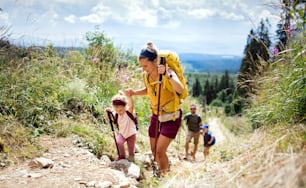 Happy family with small children hiking outdoors in summer nature, walking in High Tatras.