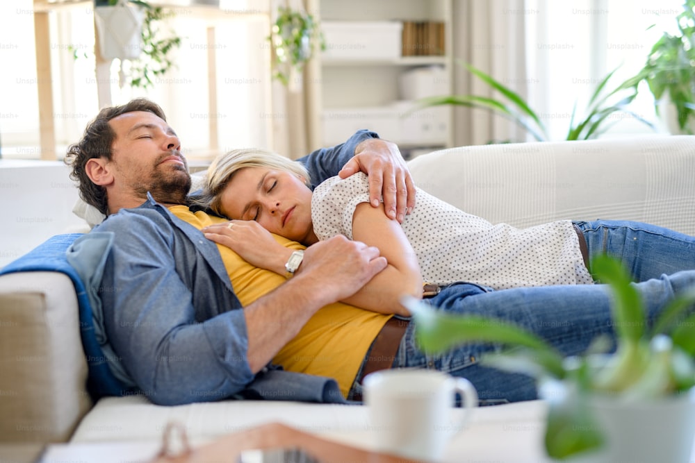 Feliz pareja enamorada acostada en el sofá en el interior de la casa, durmiendo.