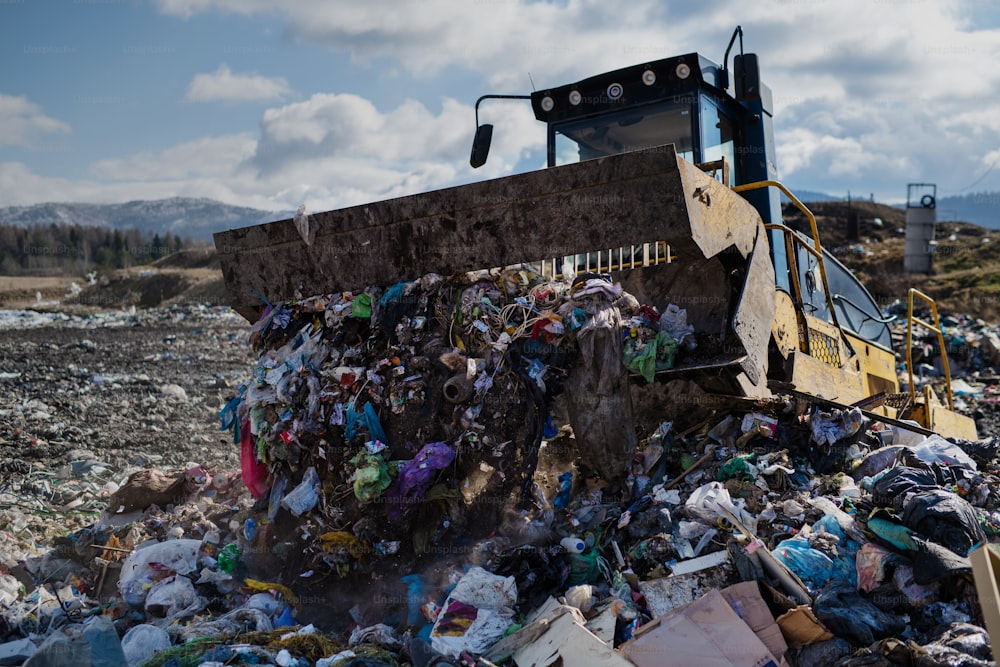 Camion della spazzatura che scarica rifiuti in discarica, concetto ambientale. Copia spazio.