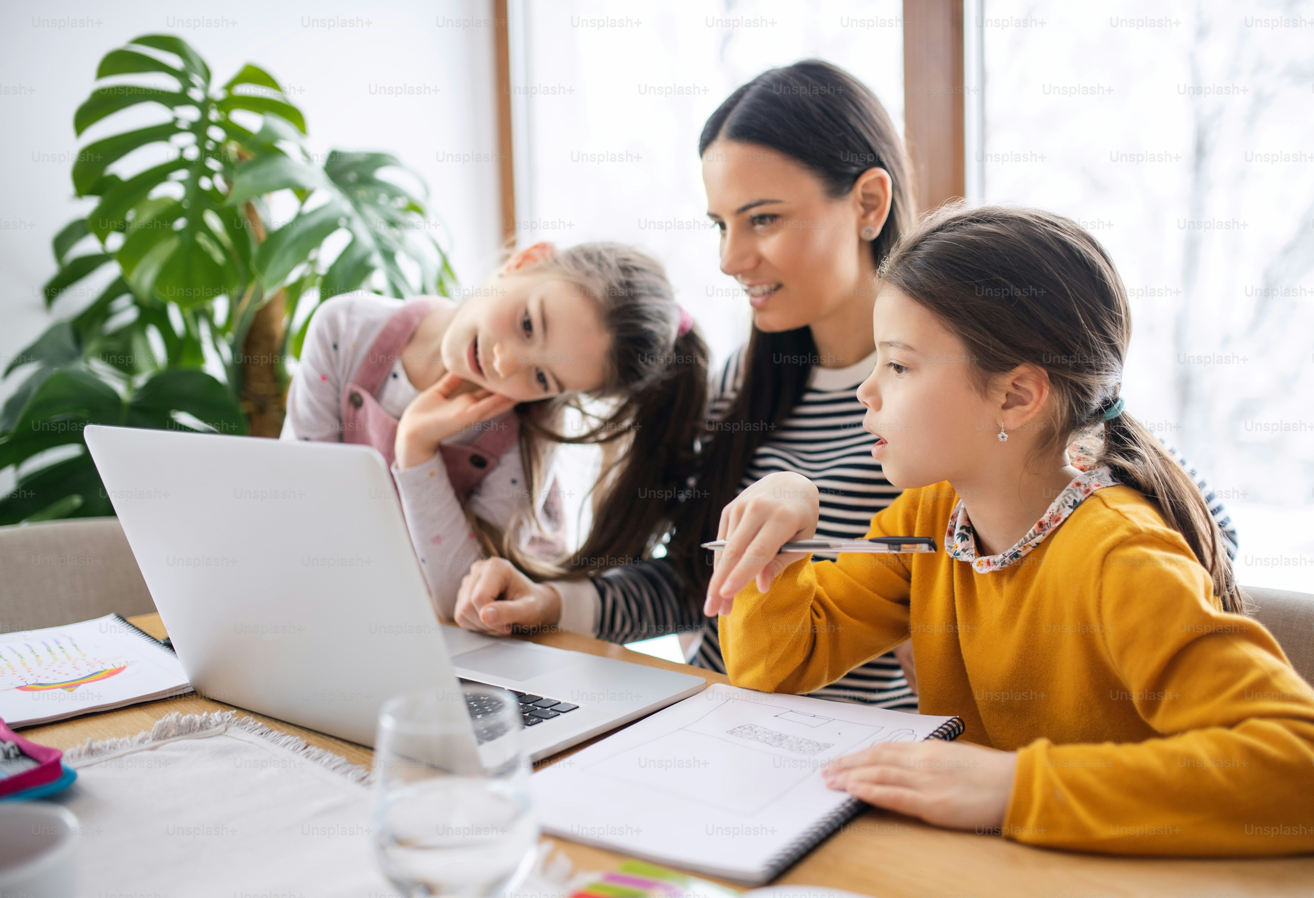 Mother with school girl indoors at home, distance learning and home ...