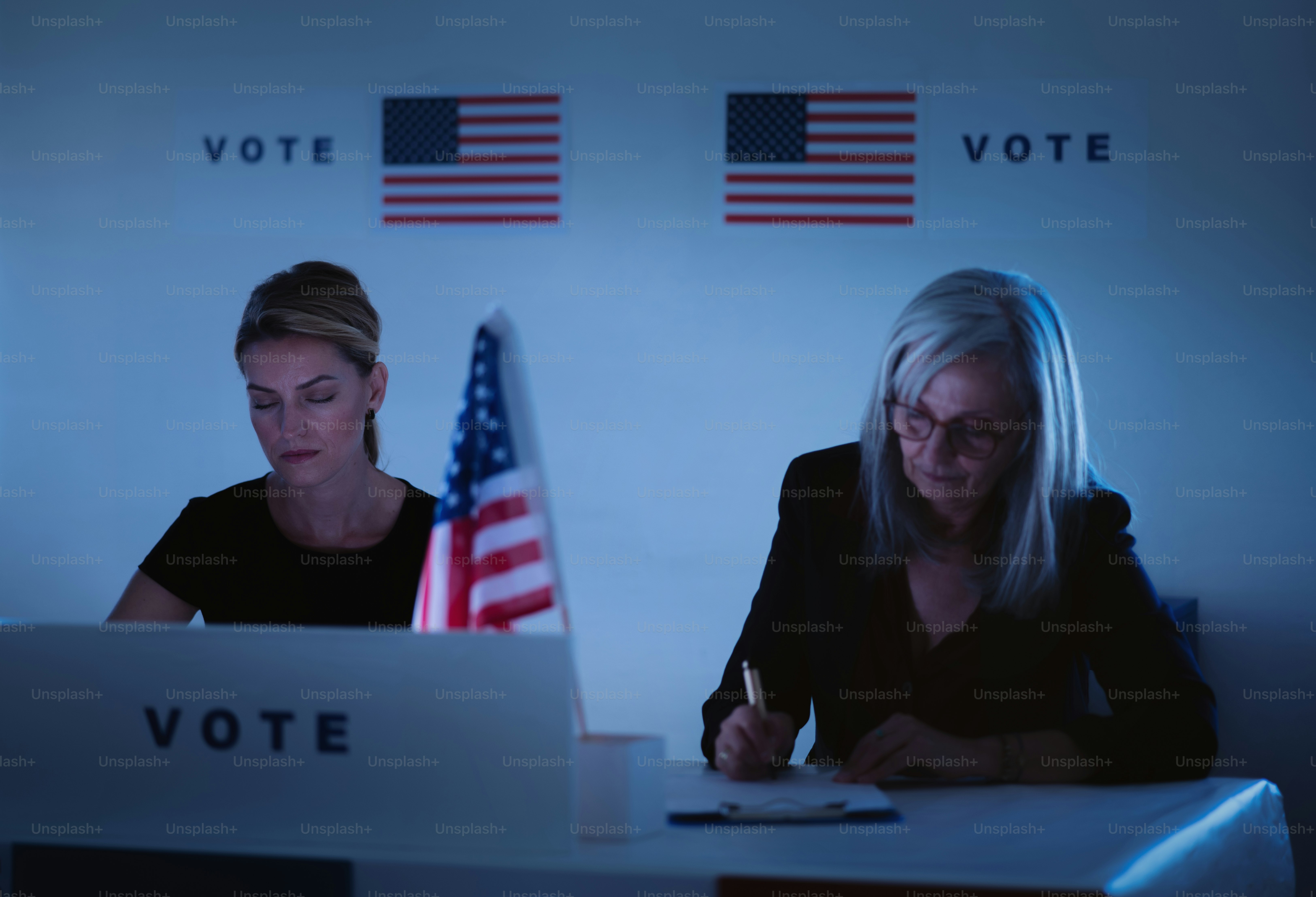 Tired women members of electoral commission in polling place at night ...