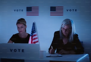 夜の投票所で疲れた選挙管理委員会の女性メンバー、アメリカの選挙。