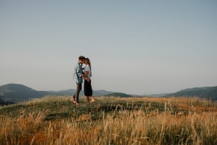 Side view of young couple on a walk in nature at sunset in countryside, kissing.