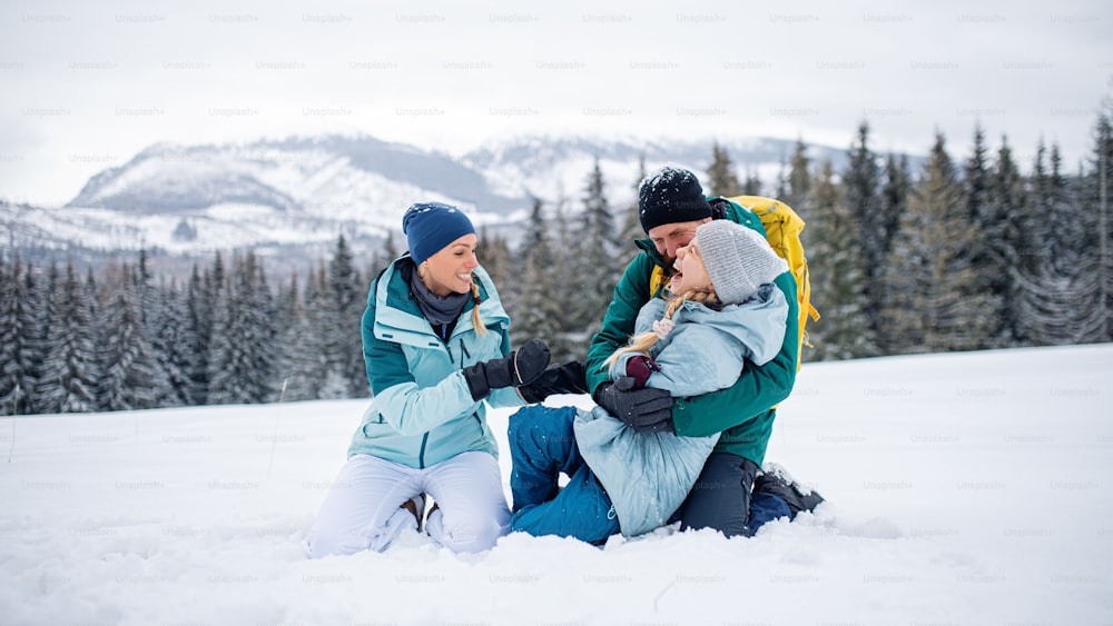 겨울 자연, 슬로바키아의 타트라 산맥에서 야외에서 즐거운 시간을 보내는 작은 딸을 동반한 가족.