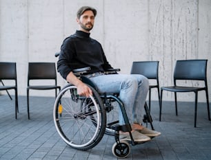 A portrait of sad man in wheelchair on group therapy, looking at camera.