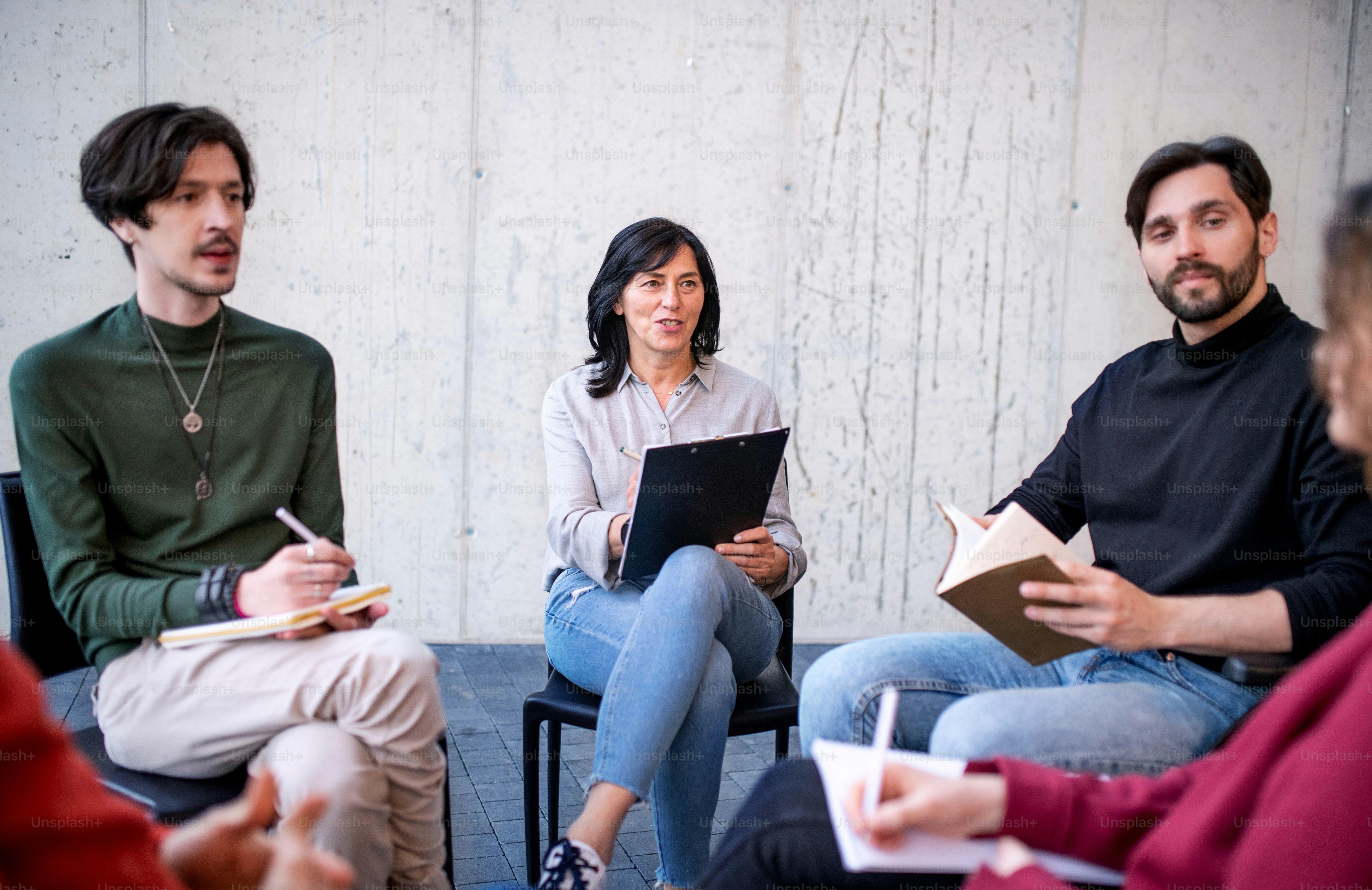 A counselor with men and women sitting in circle during group therapy, talking