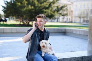 街中で犬を連れた若い男性がスマートフォンを使って屋外で撮影しているポートレート。