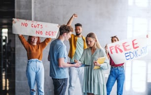 University students activists protesting indoors at school, fighting for free education concept.