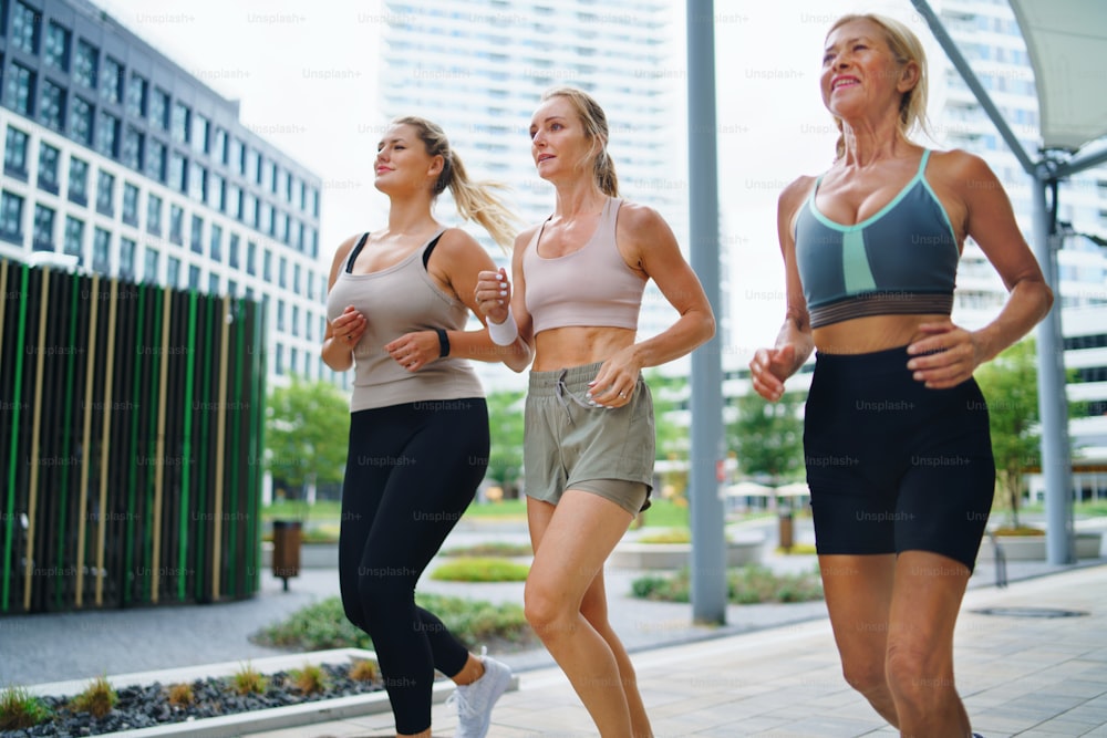 도시에서 야외에서 달리는 젊은이와 노인 여성 그룹, 건강한 라이프 스타일 개념.