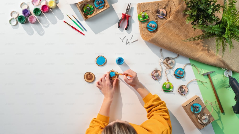 A top view of unrecognizable craftswoman making diy decorations, small business and desktop concept.
