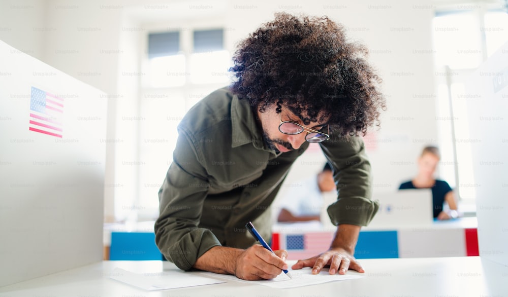 Man voter in polling place, usa elections concept, writing.