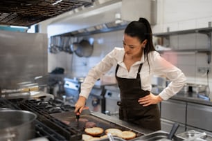 Una chef professionista che prepara il pasto all'interno della cucina del ristorante.
