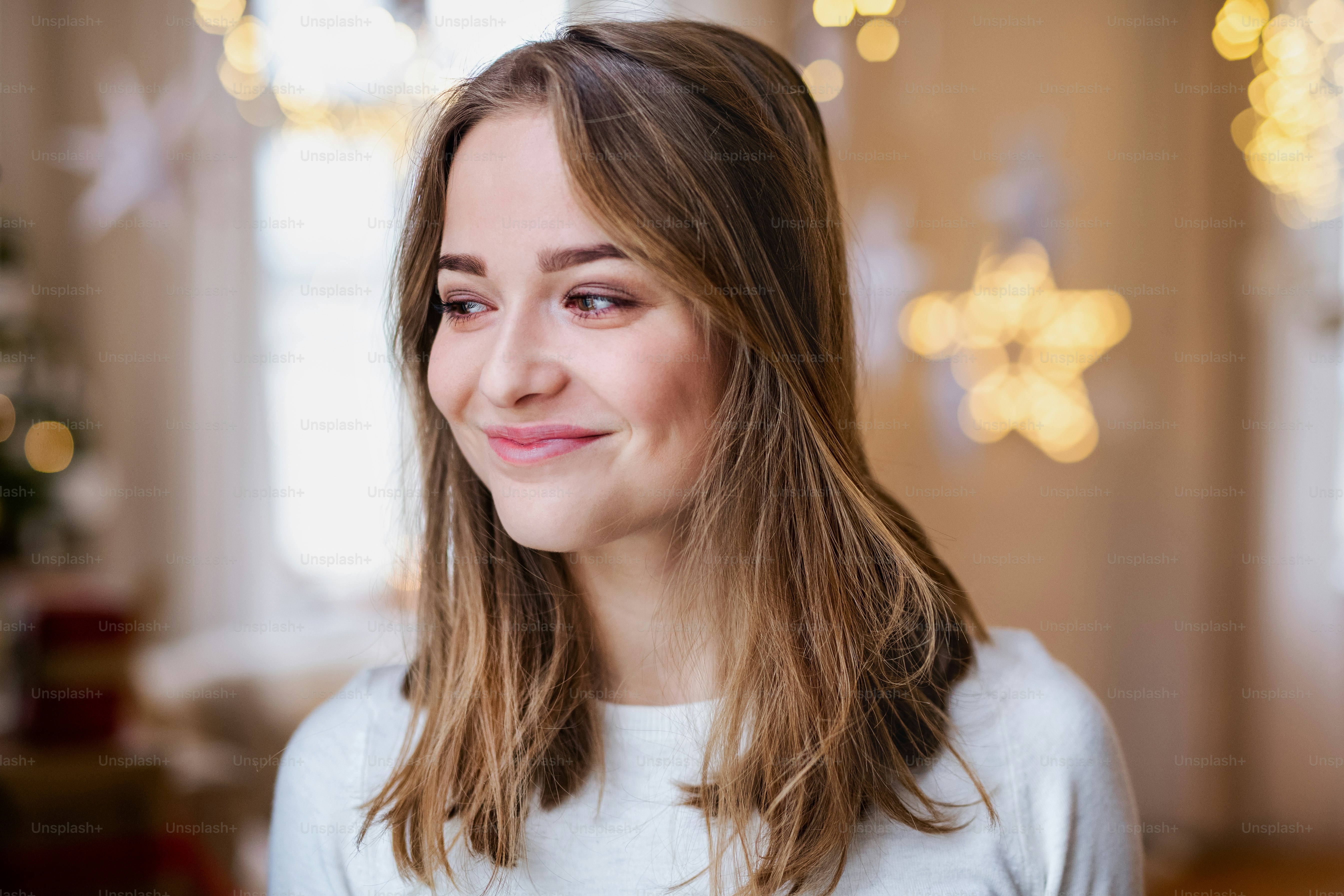 Portrait of happy young woman indoors at home at Christmas, standing.