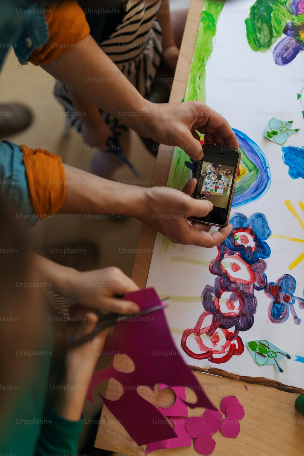 학교에서 창작 예술 및 공예 수업 중에 아이들에게 스마트폰으로 사진을 보여주는 교사의 클로즈업