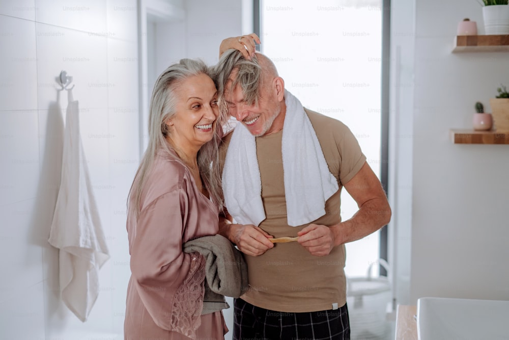 Una pareja de ancianos enamorada en el baño, divirtiéndose, concepto de rutina matutina.