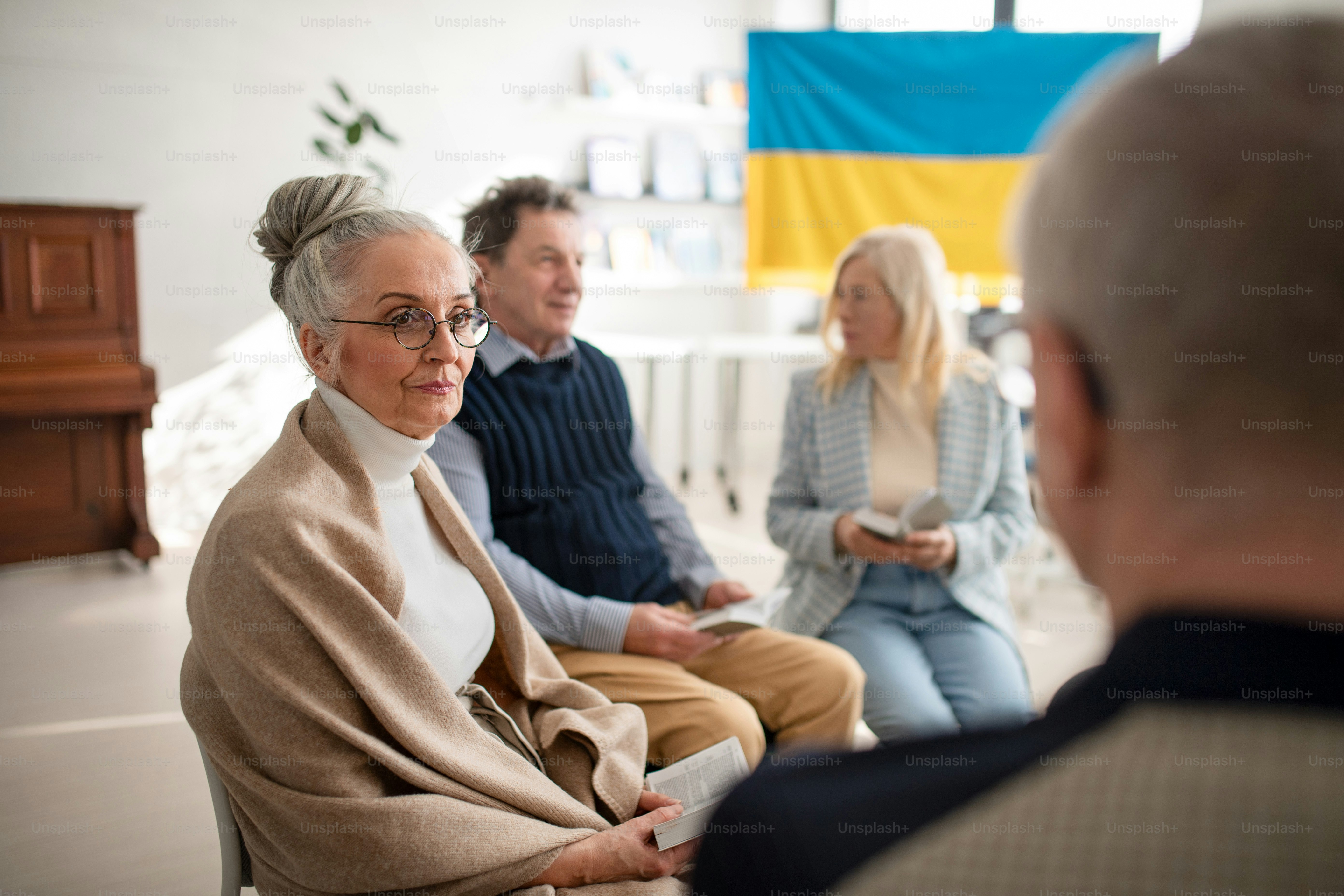 Un grupo de ancianos orando juntos por Ucrania en el centro comunitario de la iglesia.