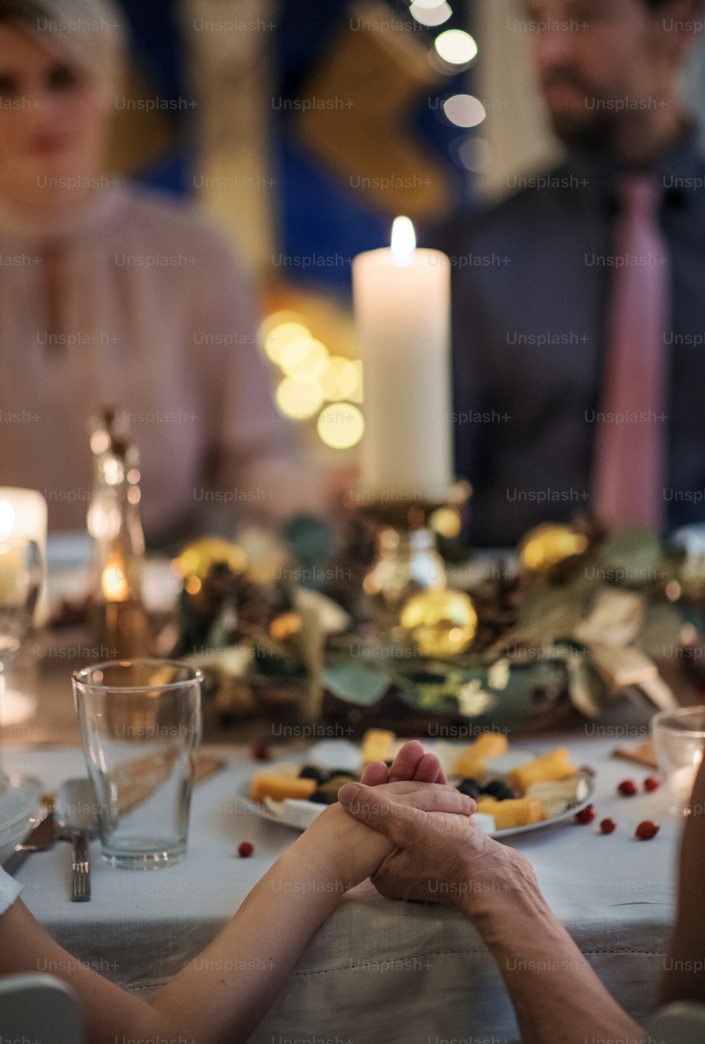 Close-up of hands holding together at the table at Christmas, detail.