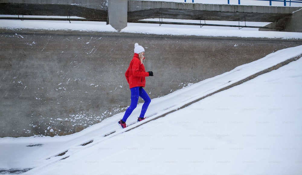 Uma mulher idosa ativa ao ar livre no inverno nevado, fazendo exercícios.