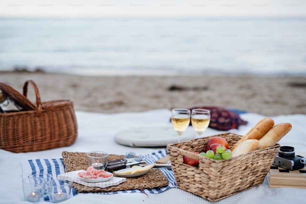 Un picnic en la playa con schripms, cerveza, velas.