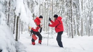 Servicio de rescate de montaña en operación al aire libre en invierno en un bosque, encontrando a una persona después de una avalancha.
