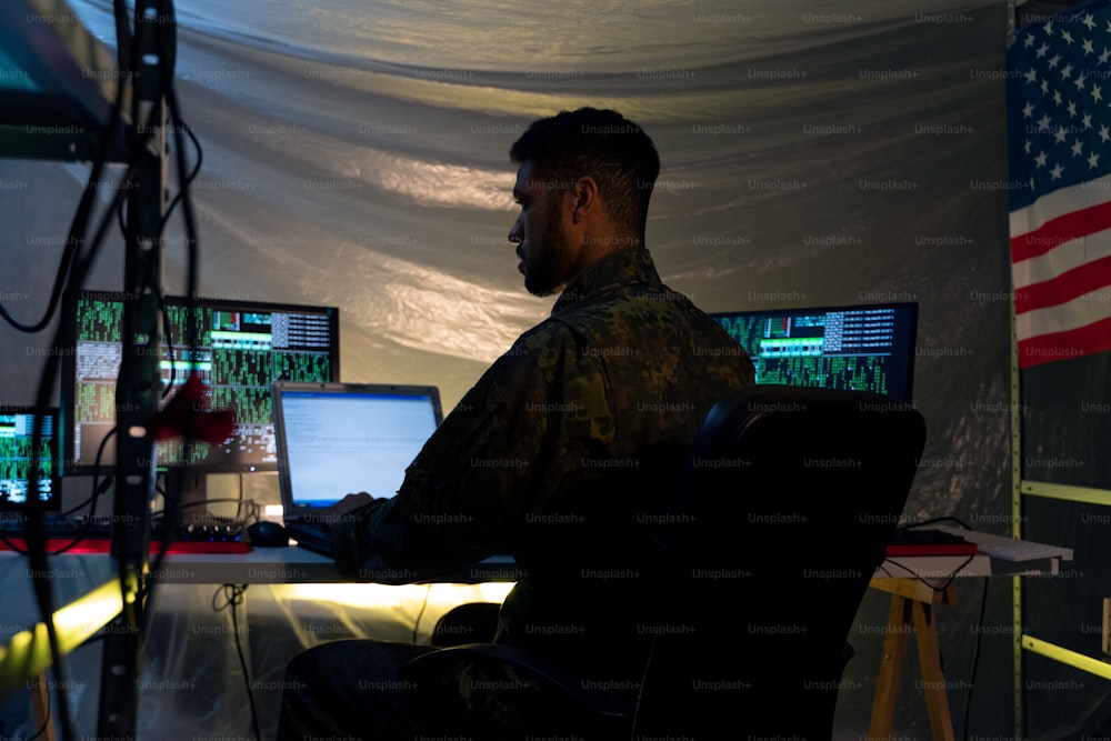 Un hacker estadounidense con uniforme militar en la web oscura, concepto de ciberguerra.
