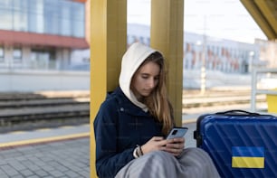 Una joven inmigrante ucraniana deprimida sentada y esperando en la estación de tren.