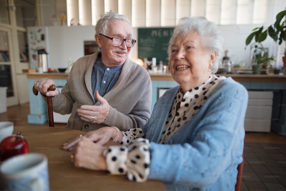 웃고 있는 노인 여성과 요양원 케어 센터에서 아침 식사를 즐기는 남성.