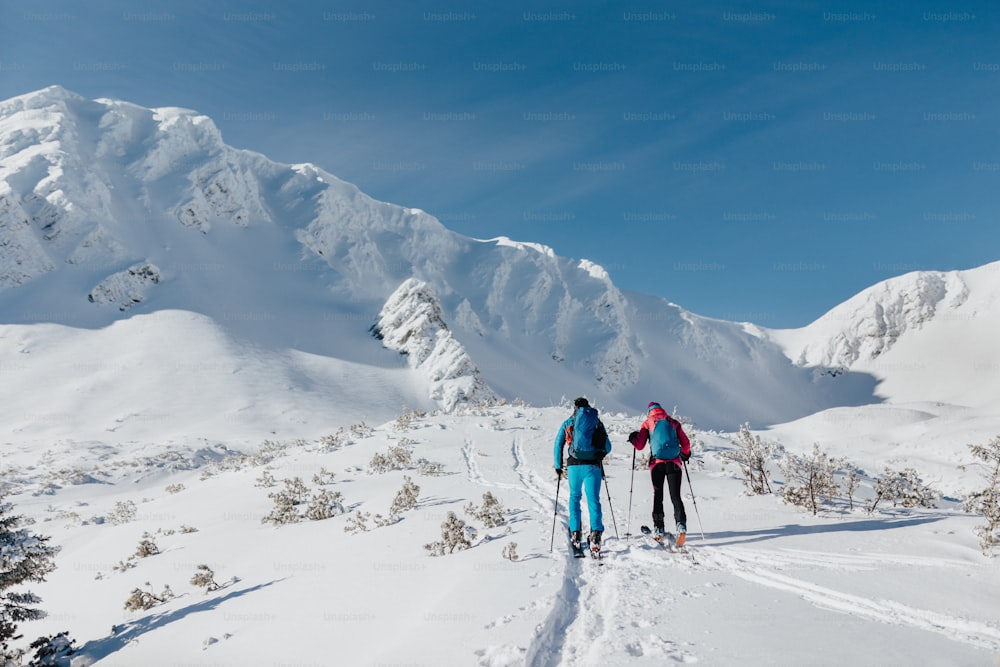 A rear view of ski touring couple hiking up a in the Low Tatras in Slovakia.