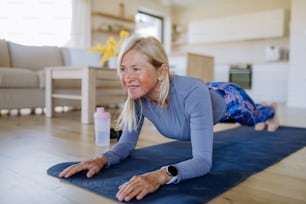 Una mujer mayor en forma que hace ejercicio en casa, concepto de estilo de vida activo.