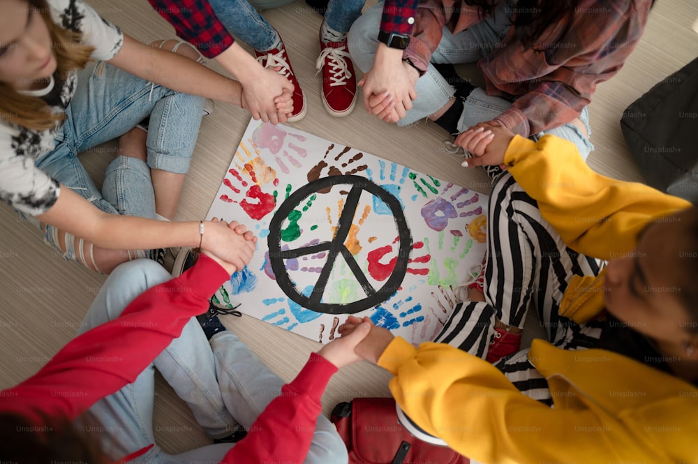 A top view of students praying for peace in world at school.