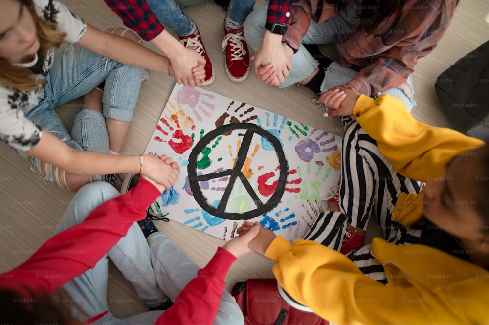 Uma visão superior dos alunos orando pela paz no mundo na escola.