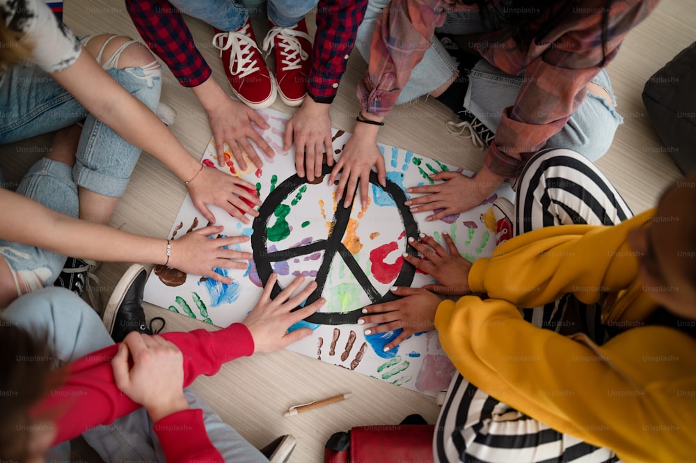 A top view of students making a poster of peace sign at school.