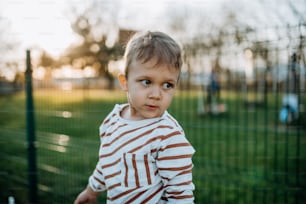 A little boy looking away outside in park