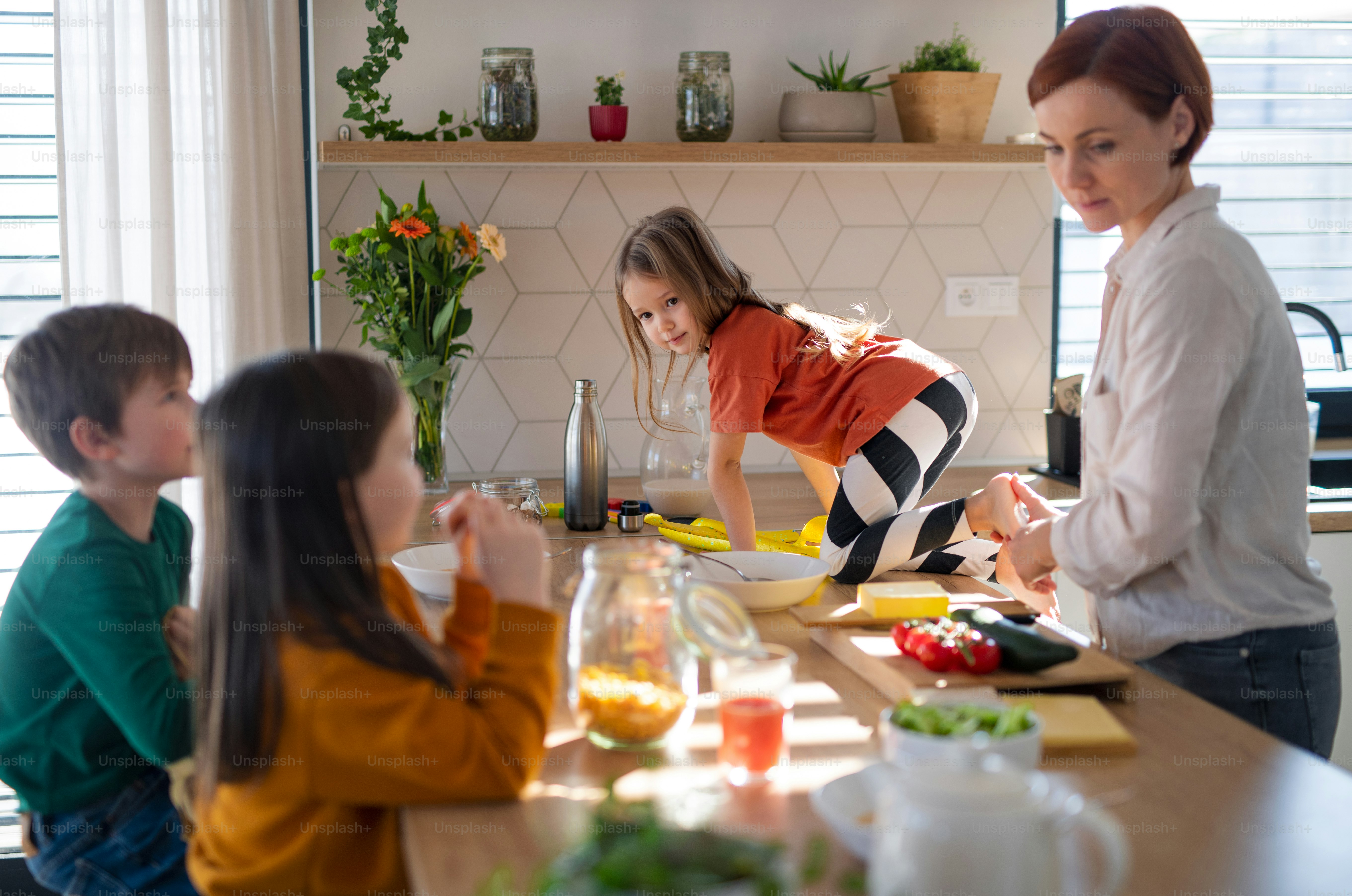 Foto Una madre de tres niños pequeños preparando el desayuno en la ...