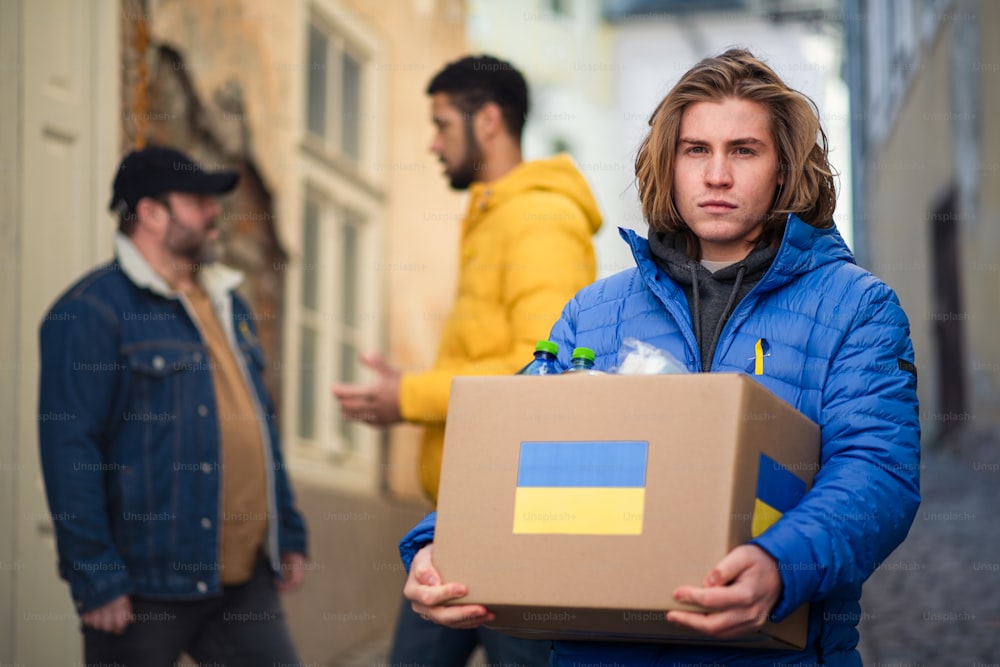 The team of volunteers collecting boxes with Humanitarian aid for Ukrainian refugees in street