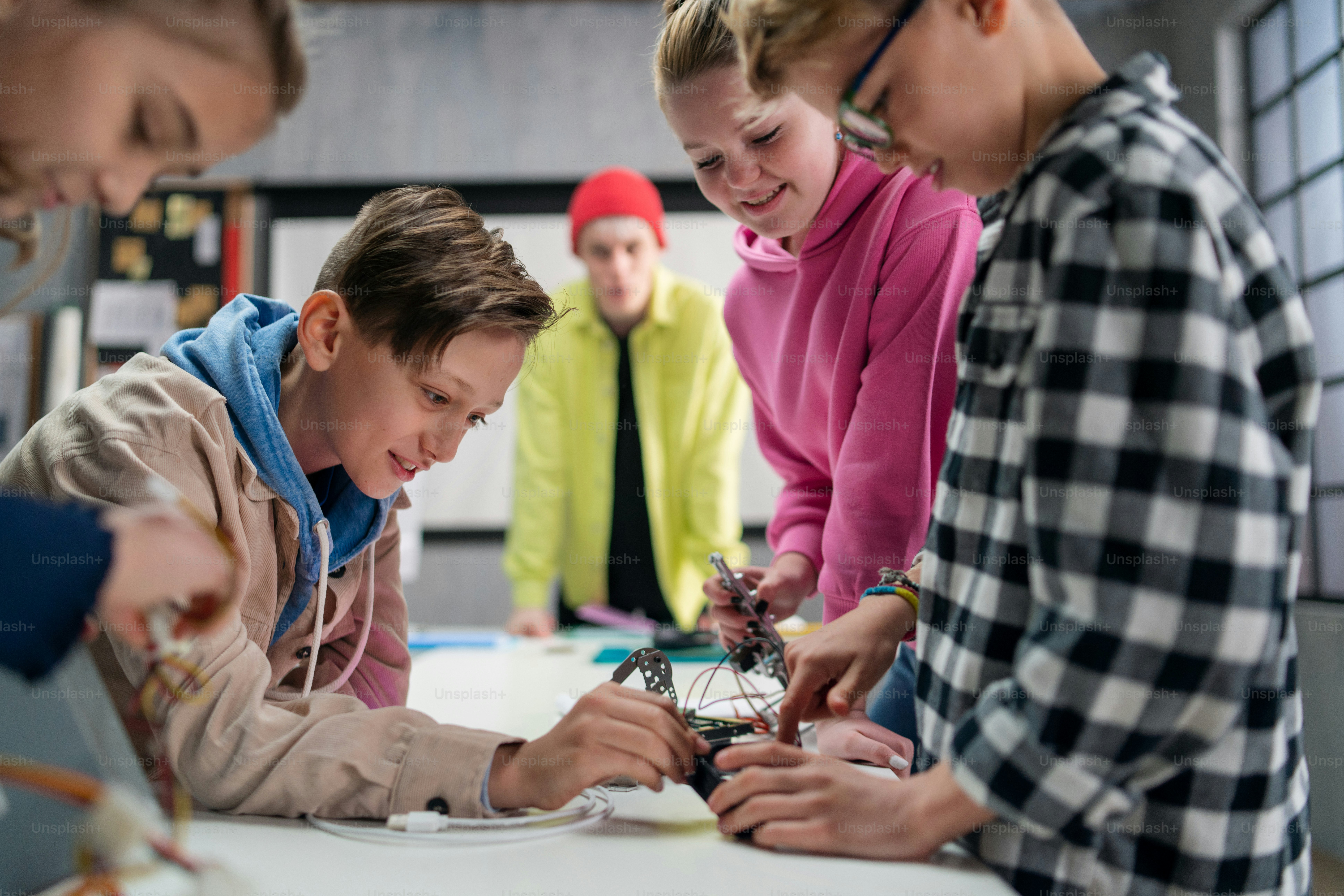 A teacher giving computer science lecture to young students in dark ...