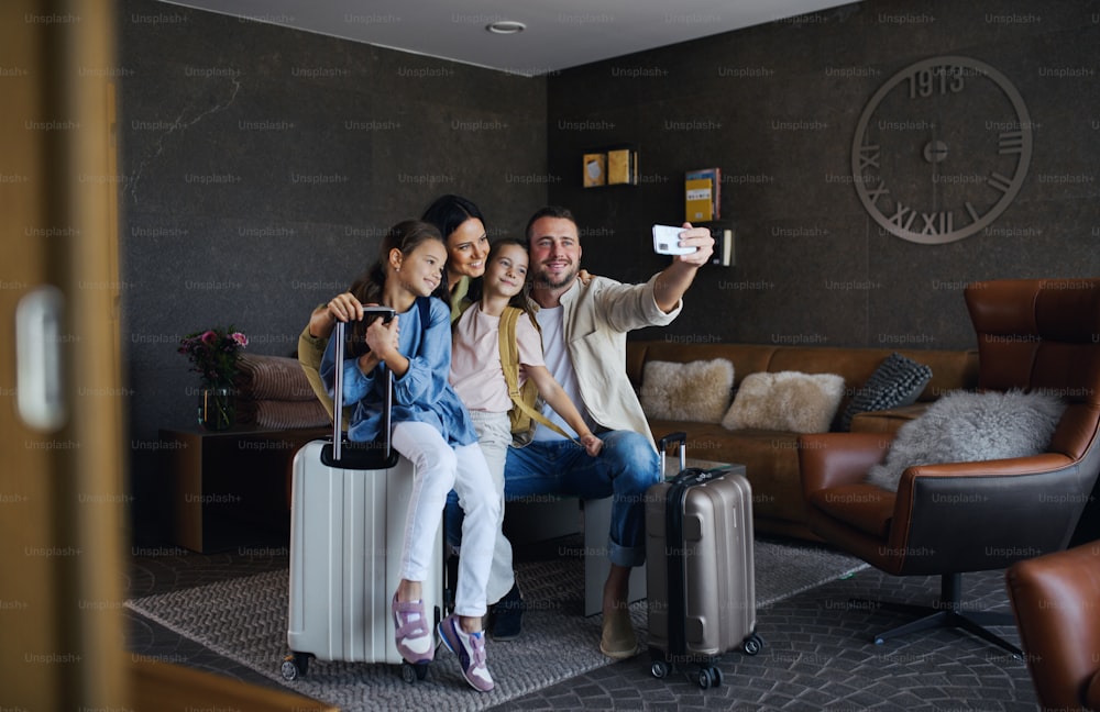 A happy young family with two children taking selfie at luxury hotel, summer holiday.
