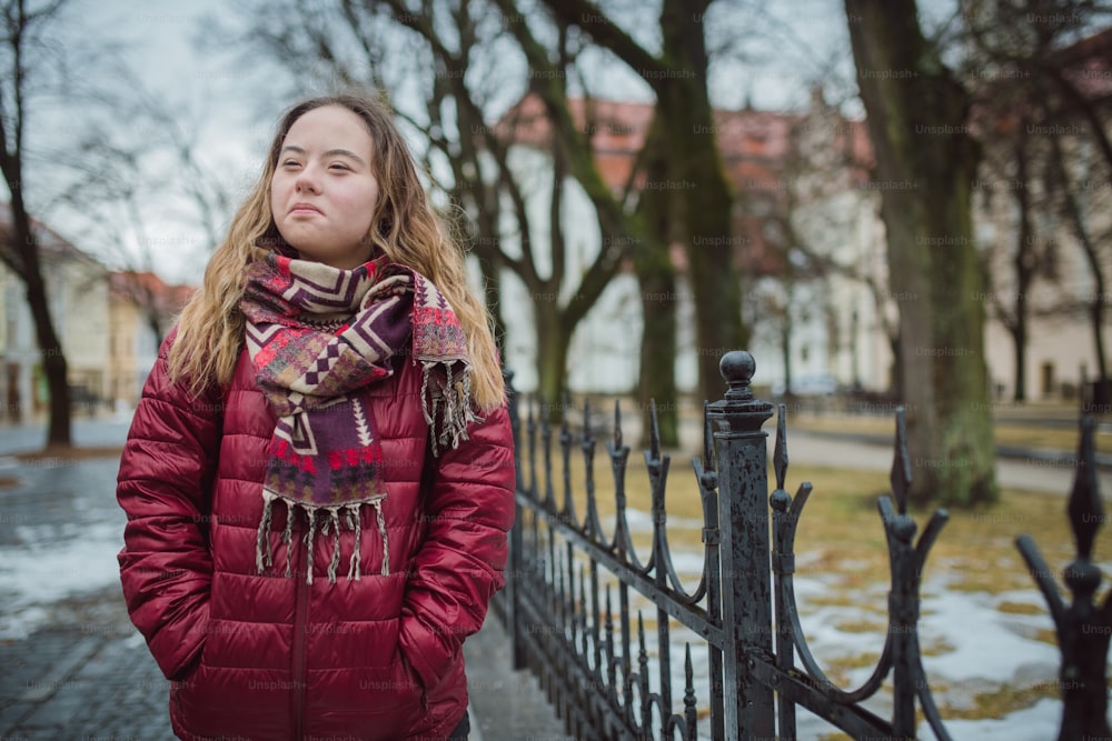 A young woman student with Down syndrome walking in street in winter