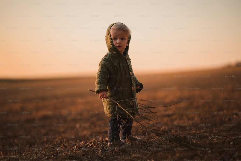 Un niño curioso paseando por la naturaleza, mirando a la cámara.