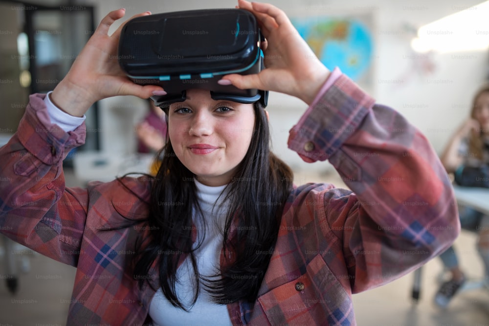 Un étudiant heureux portant des lunettes de réalité virtuelle à l’école en cours d’informatique