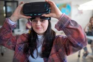 A happy student wearing virtual reality goggles at school in computer science class