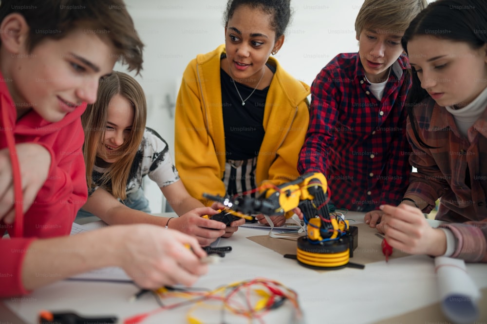 Eine Gruppe von Schülern, die elektrisches Spielzeug und Roboter im Robotik-Klassenzimmer bauen und programmieren